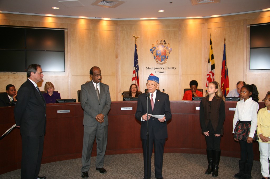 Terry Shima’s remarks, Montgomery County, Maryland, November 27, 2012.  L-R:  Council President Berliner; County Executive Leggett; Shima, Kendall Griffith; Analya Rice, daughter of Councilman Rice (seated extreme left facing camera); Leilani Meyers and (not in photo) Lauren Penn.  Photo by Neil Greenberger.